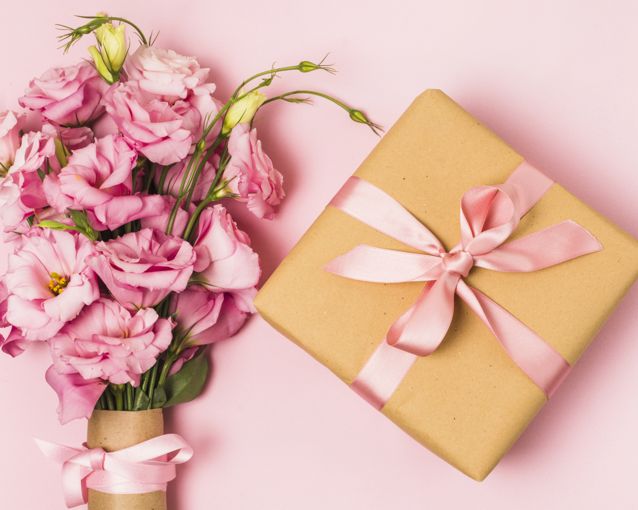 Большой букет эустомы с подарком на розовом фоне