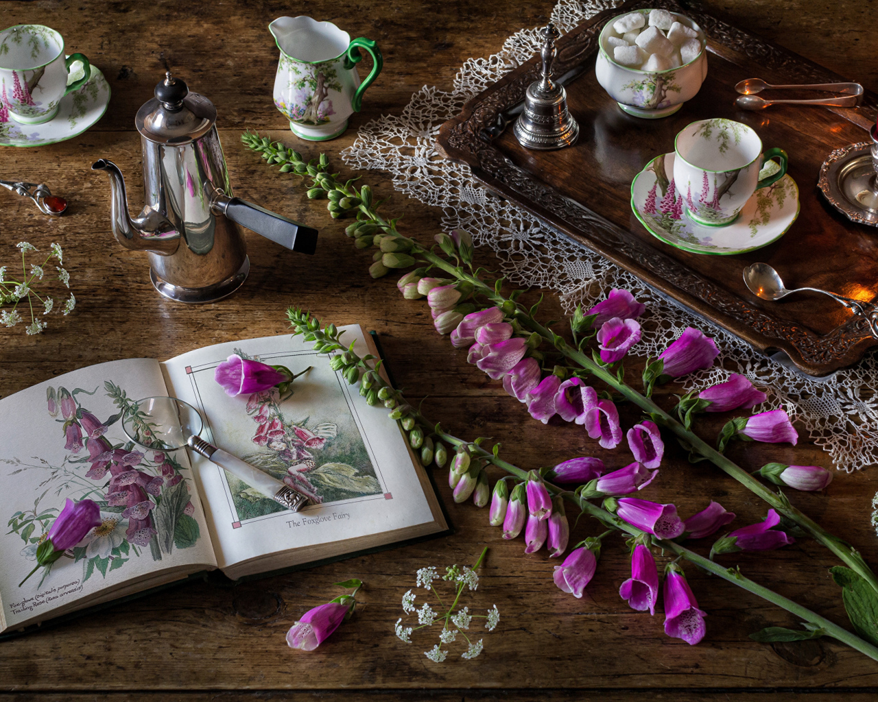 Розовые цветы на столе с книгой и чаем