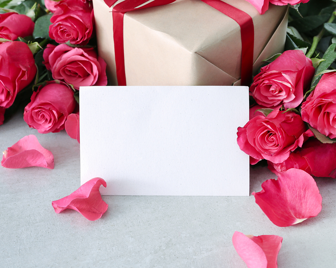 Лист бумаги с розовыми розами и подарком для открытки