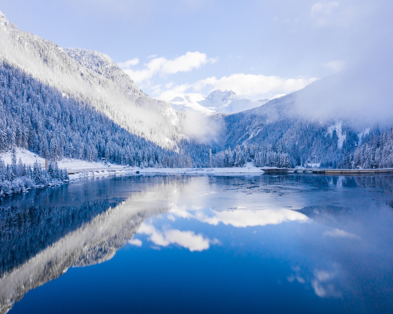 Покрытые снегом горы у покрытого льдом озера