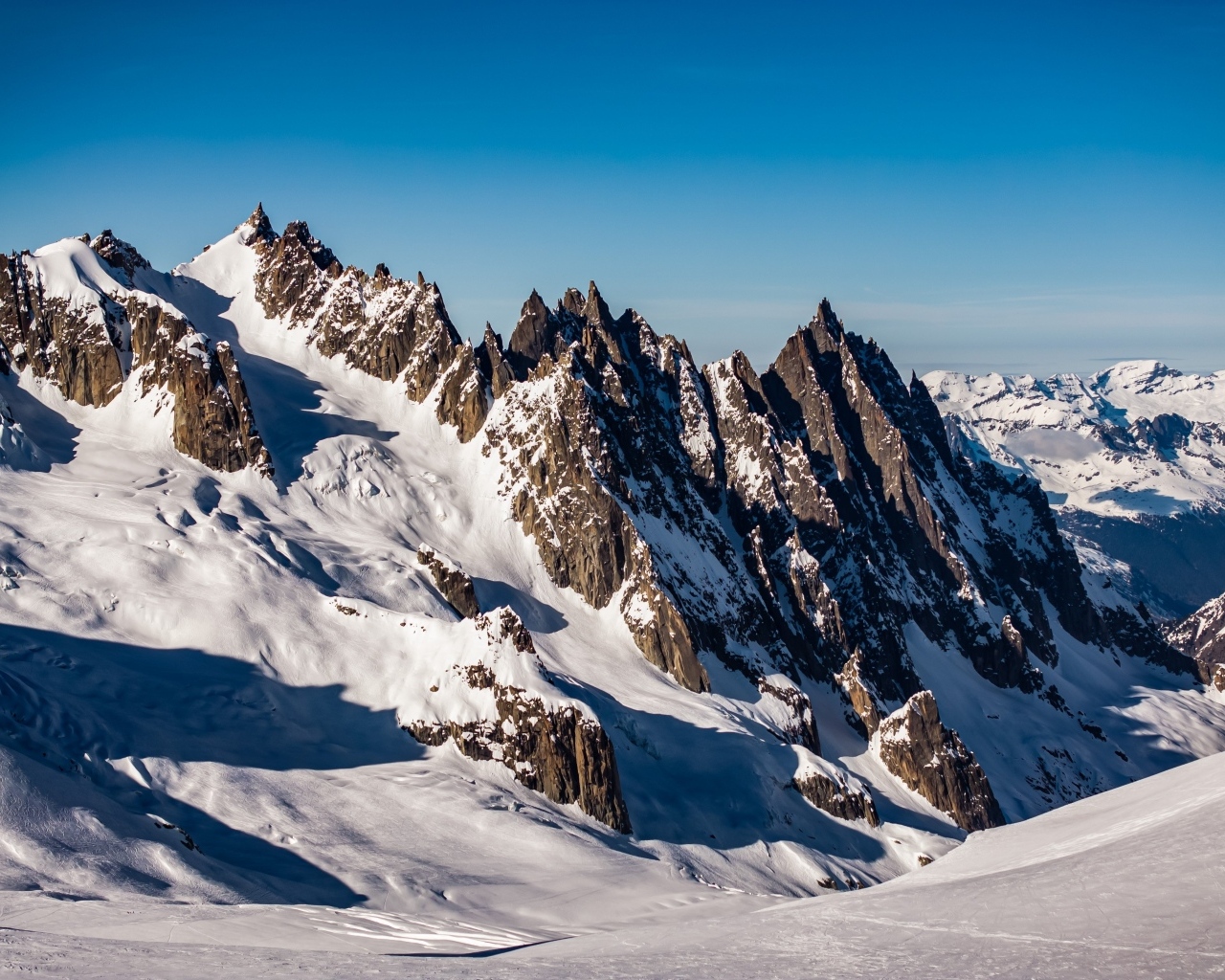 Солнце покрывает заснеженные горы