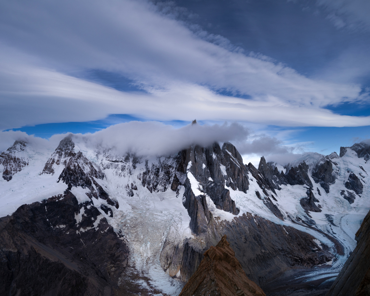 Белые облака над холодными заснеженными горами