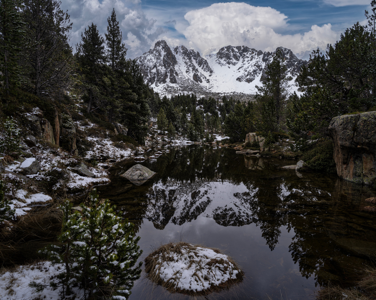 Холодная вода в озере с большими камнями на фоне гор