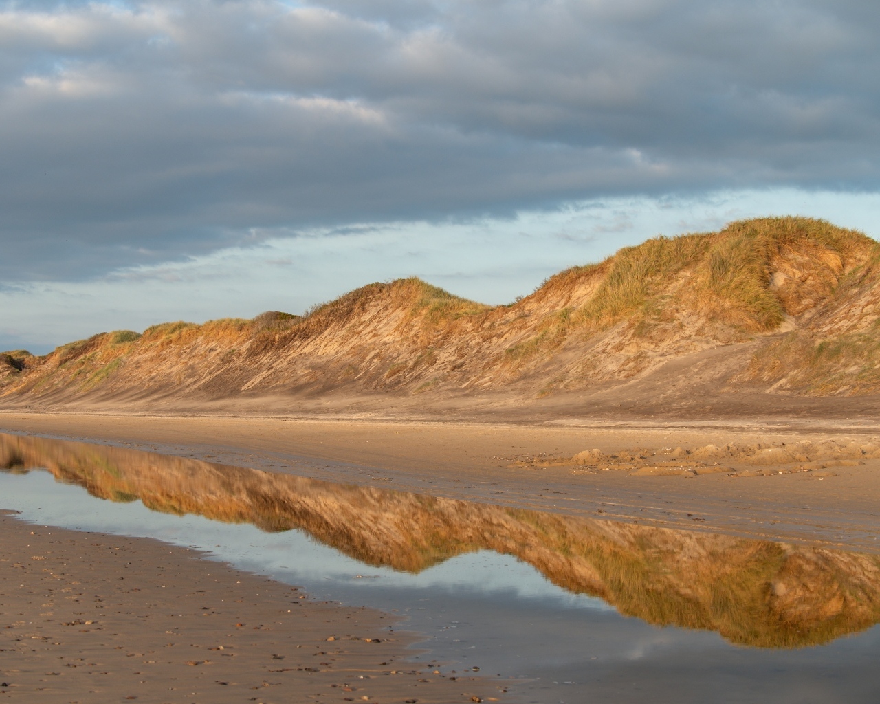 Холты отражаются в реке под грозовым небом