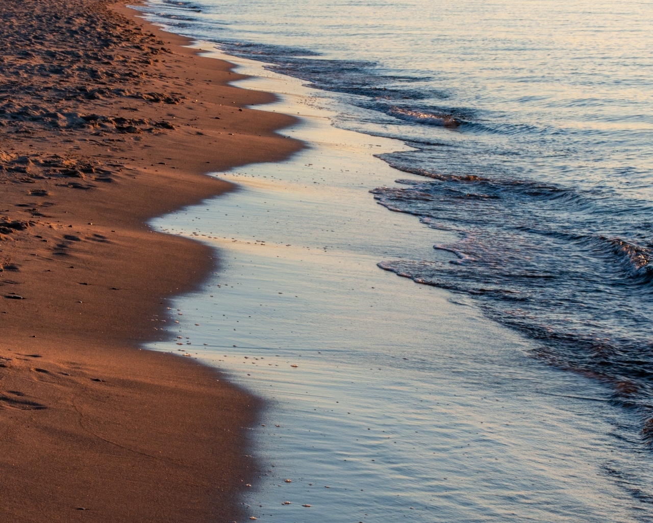 Спокойное море на морском песке на рассвете