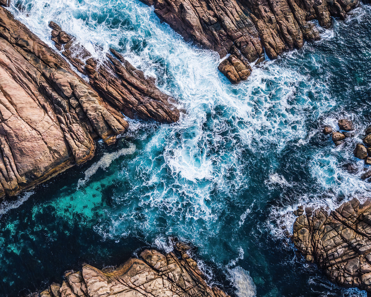 Вид на бушующее голубое море между камней 