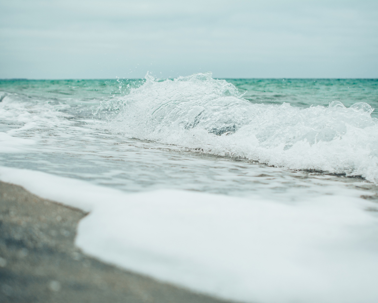 Белая морская пена на морском песке вблизи