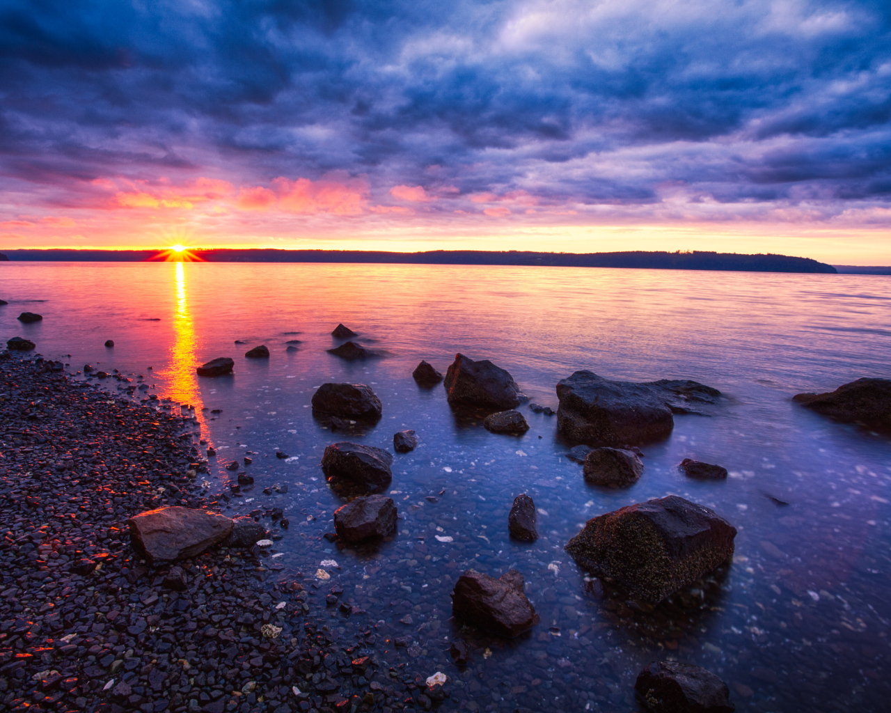 Закат солнца в пасмурном небе у озера