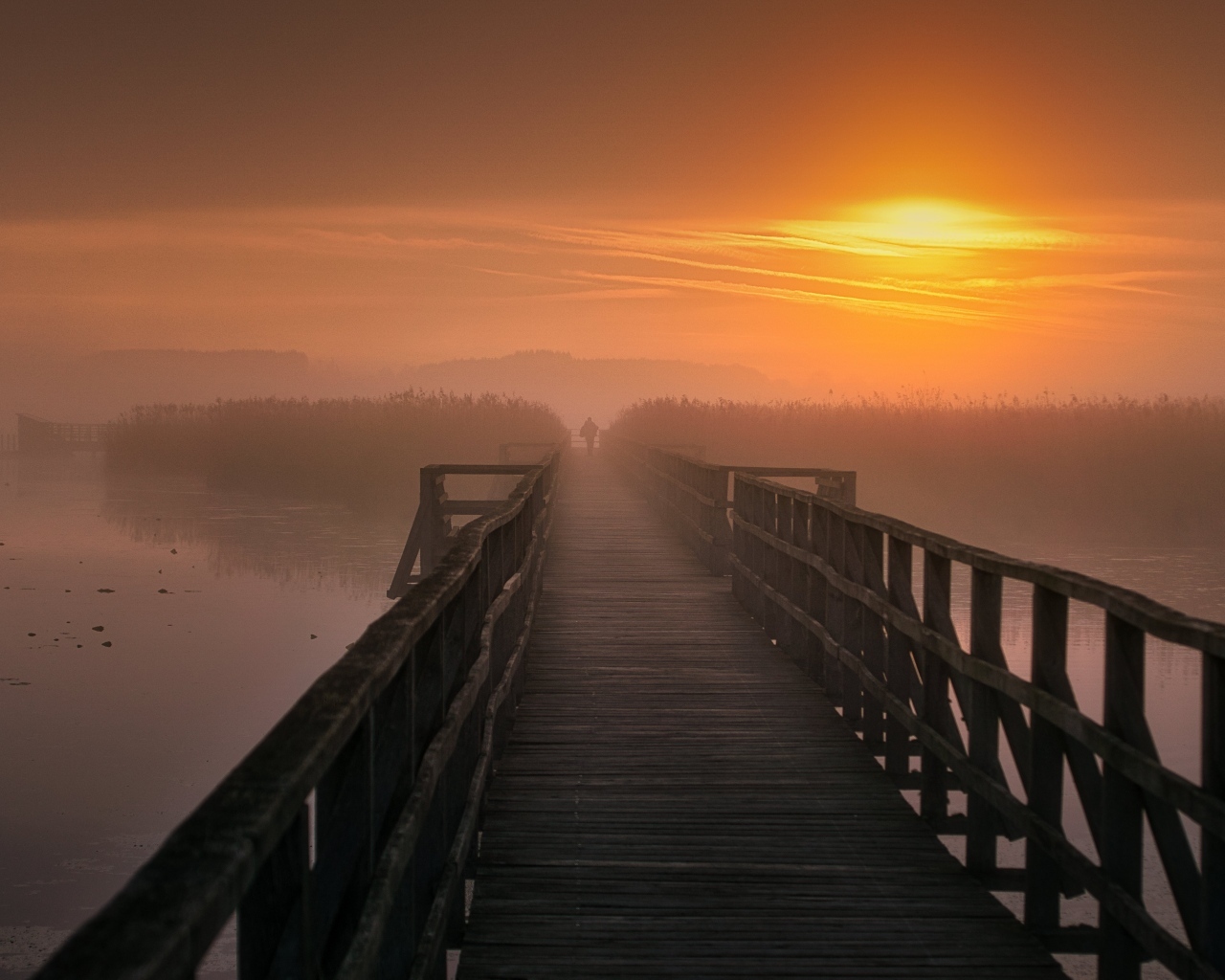 Деревянный мост над рекой на закате