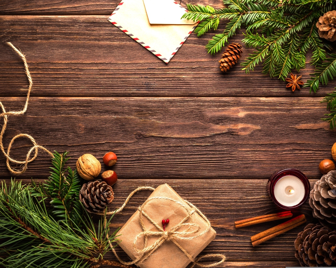 Еловые ветки, шишки, орехи и свеча на деревянном фоне с письмом