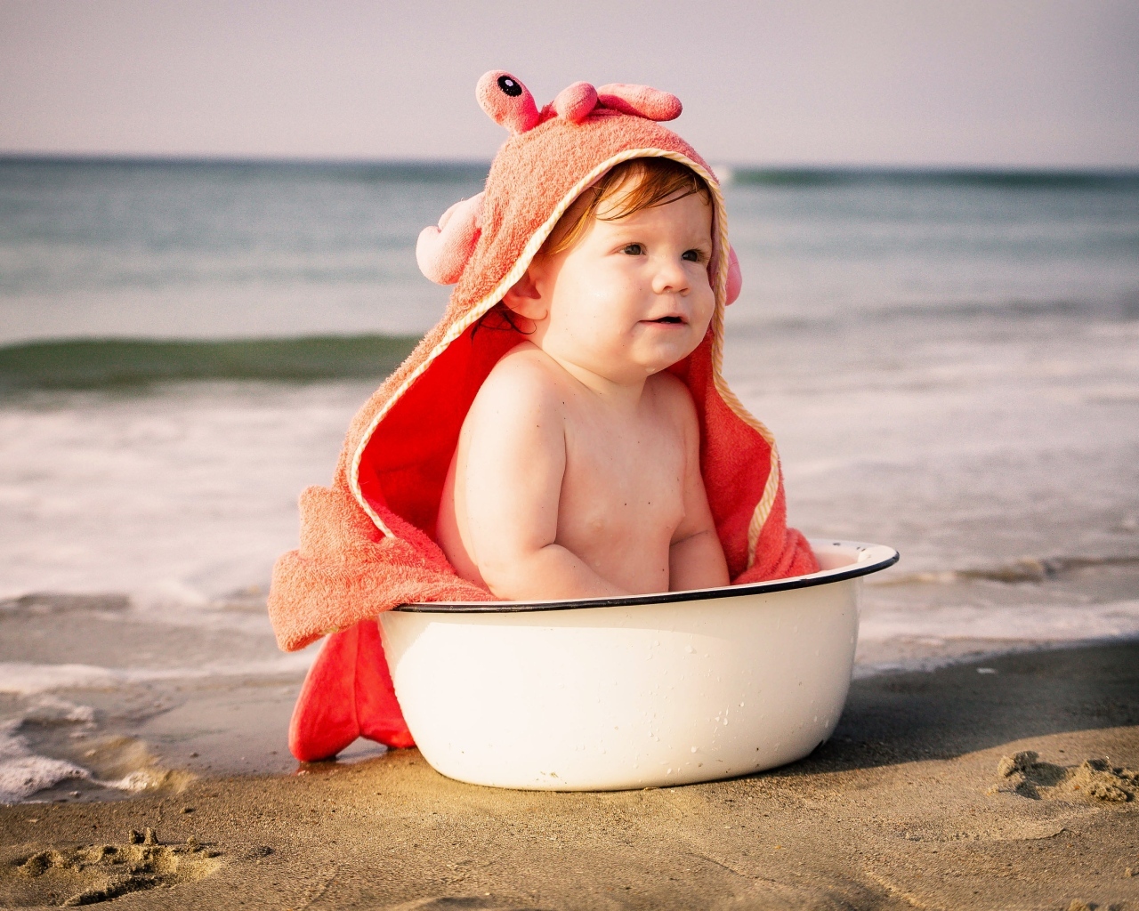 Ребенок в миске на берегу моря