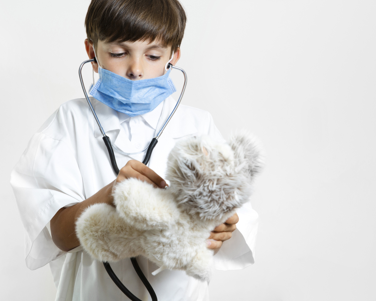 Мальчик в костюме врача с игрушечным медведем