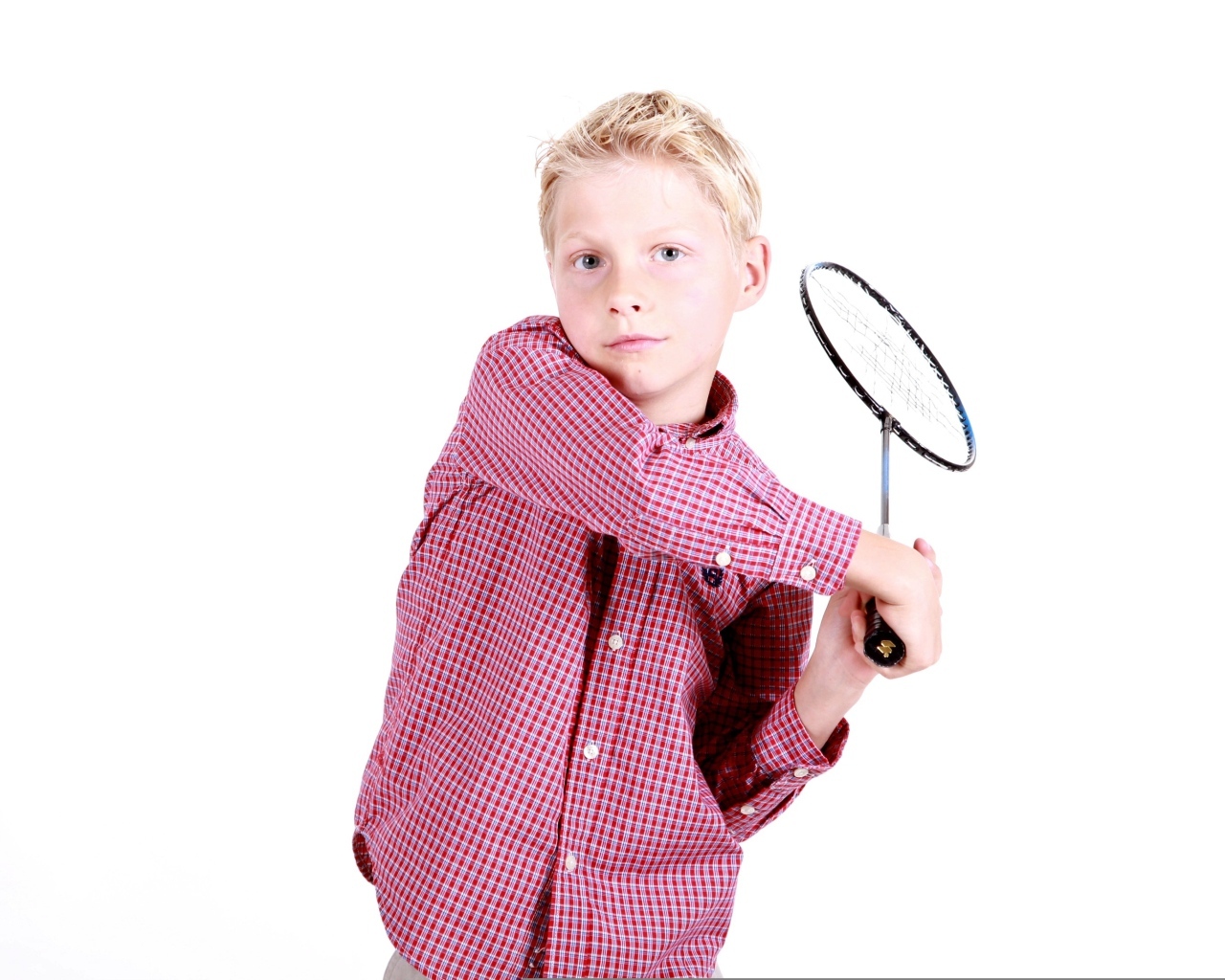 Мальчик в рубашке с ракеткой в руках на белом фоне