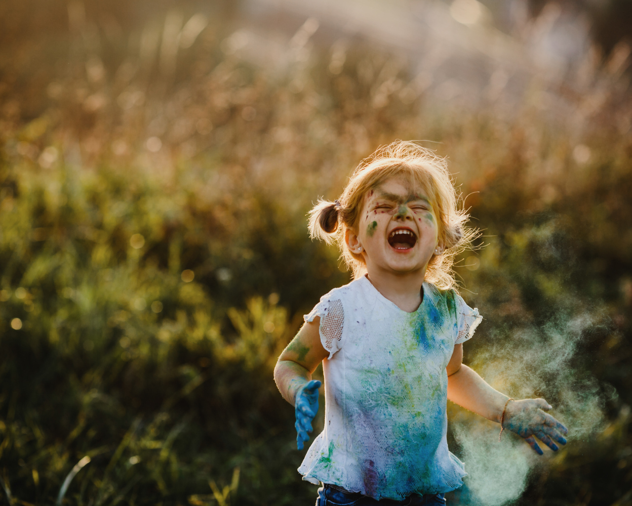 Веселая девочка в краске на улице