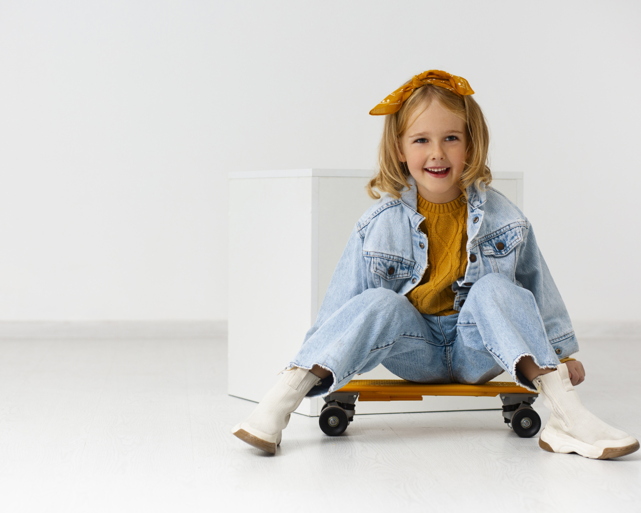 Веселая девочка на скейтборде в комнате