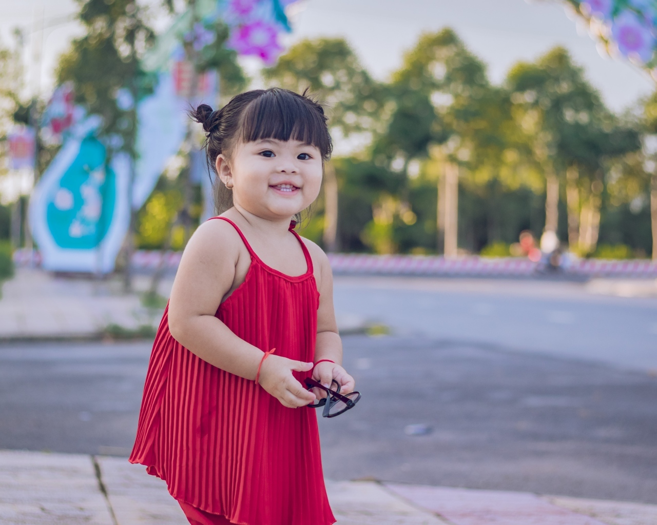 Веселая маленькая девочка азиатка в красном платье