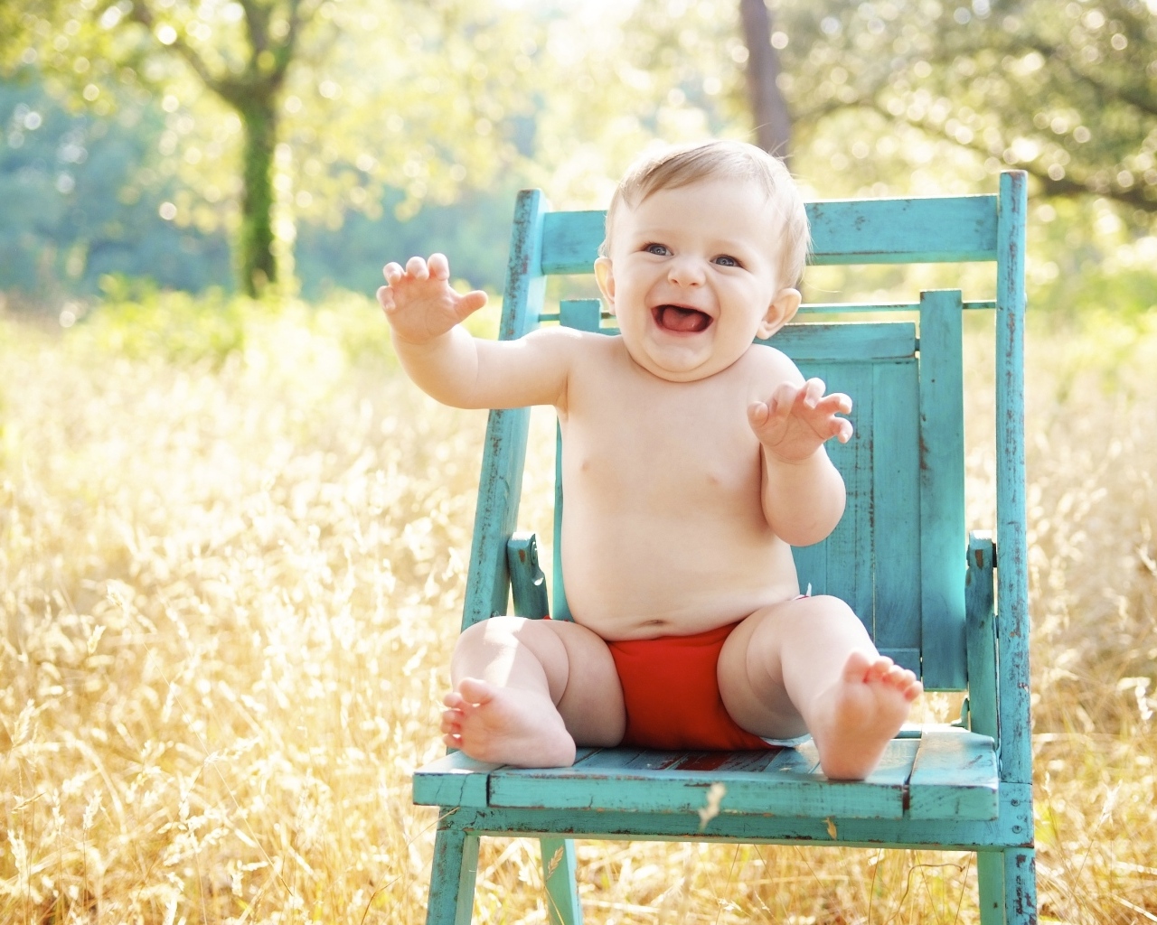 Веселый маленький мальчик в кресле 