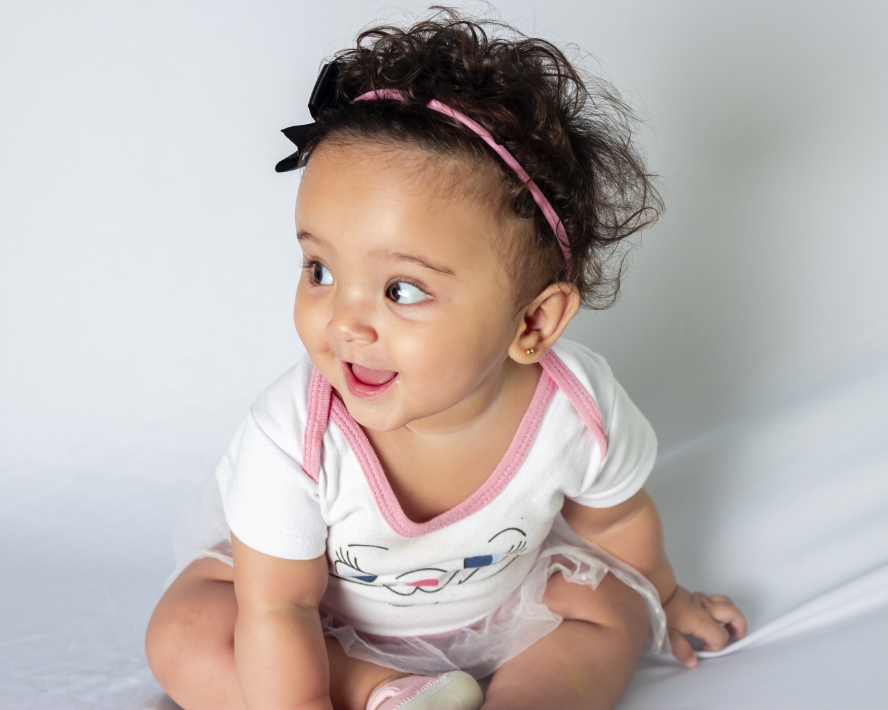 Веселая маленькая девочка с ободком на голове