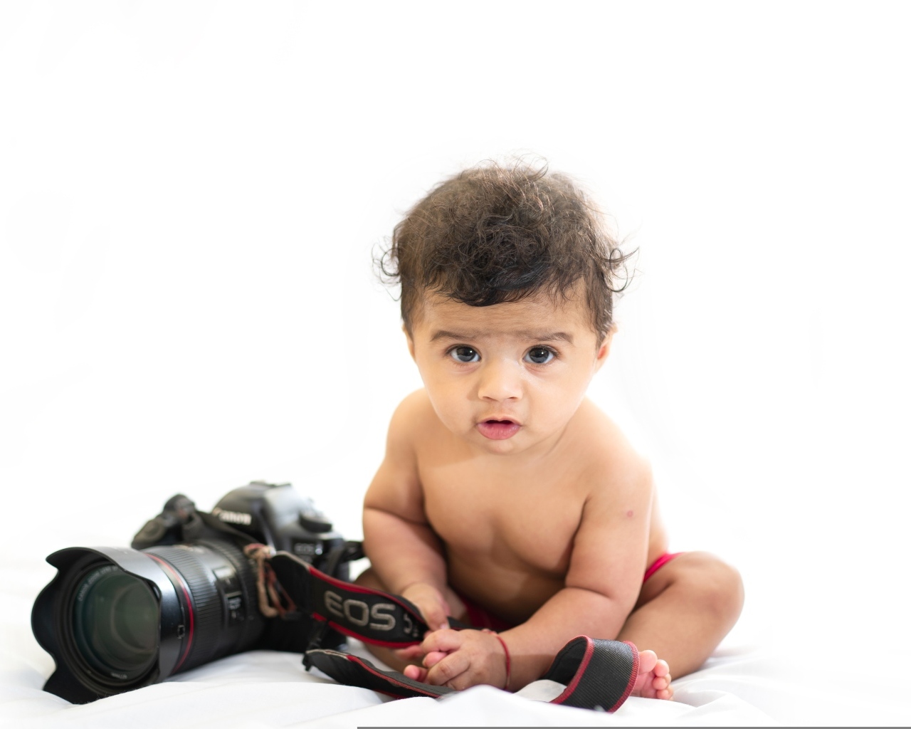 Милый ребенок с фотоаппаратом на белом фоне