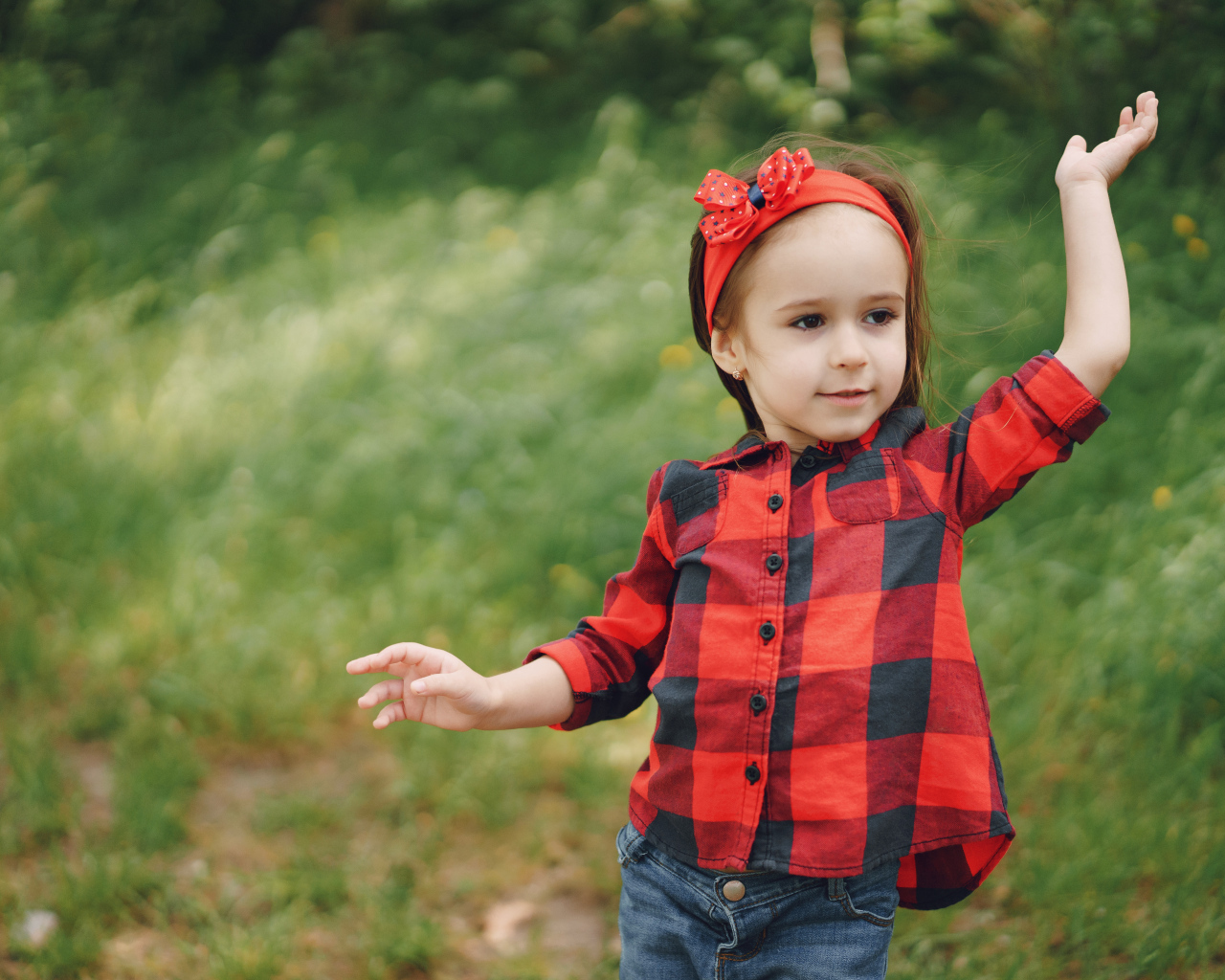 Милая девочка с красным бантом на голове 
