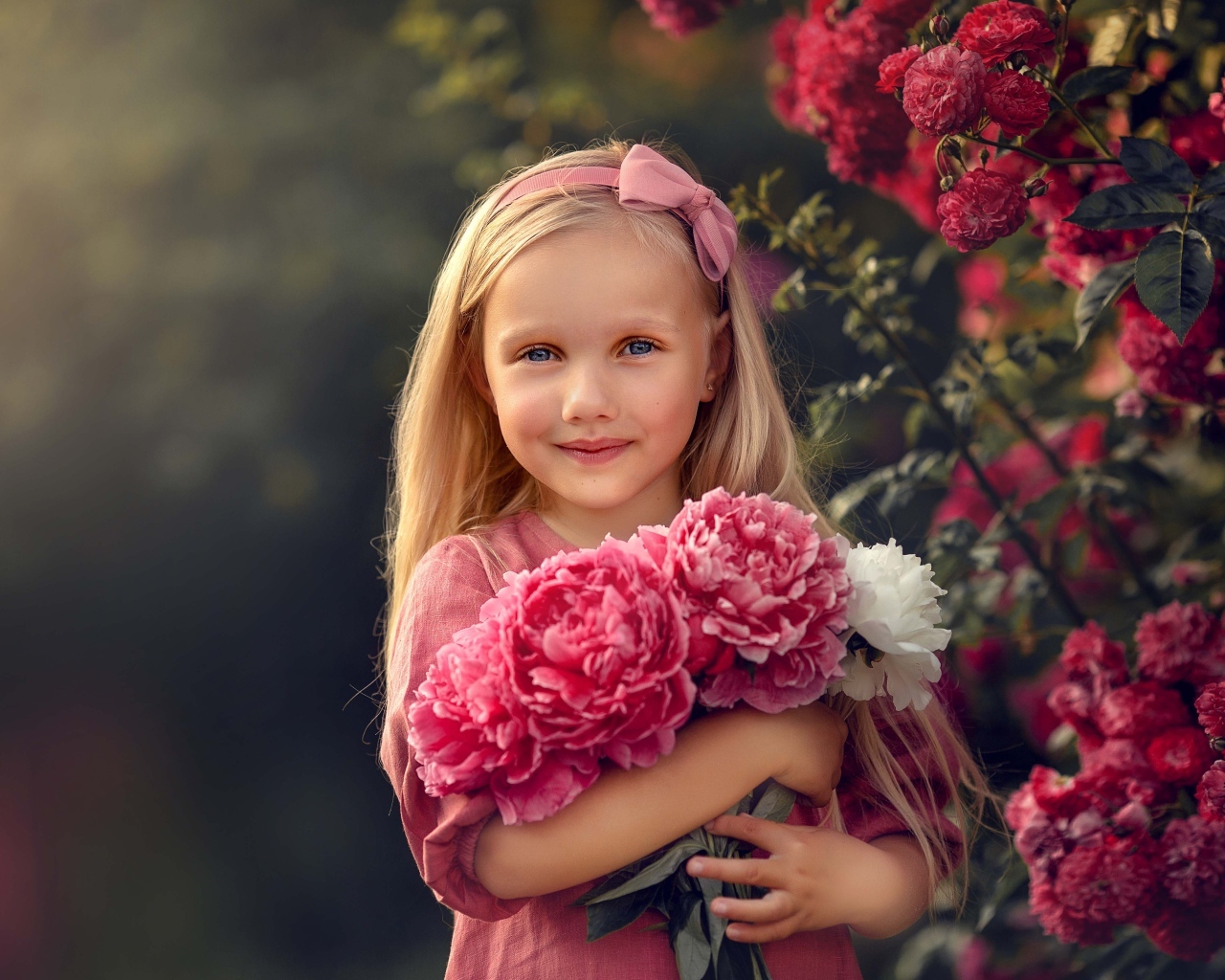 Милая маленькая девочка с букетом пионов