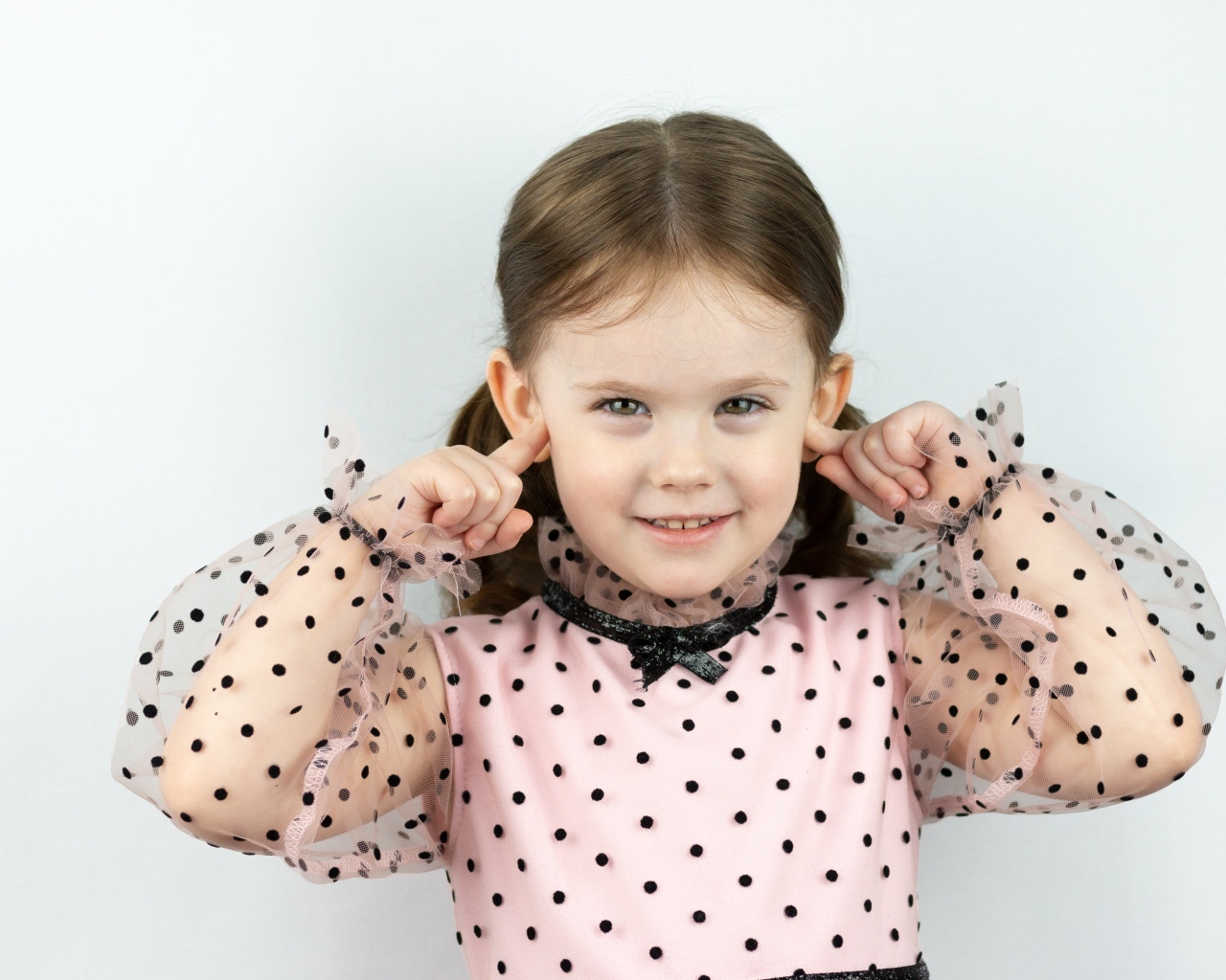 Смешная маленькая девочка закрыла уши