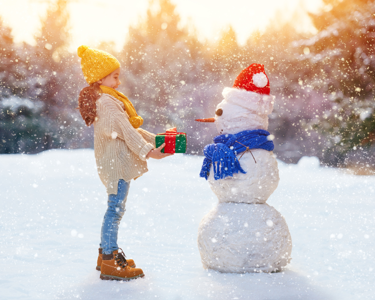 Девочка дарит подарок снеговику