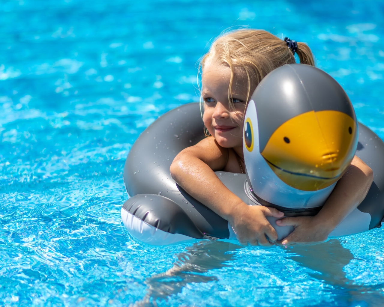 Девочка со спасательным кругом в бассейне