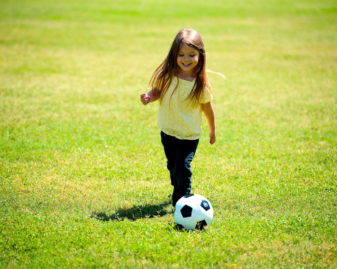 Девочка с футбольным мячом на поле