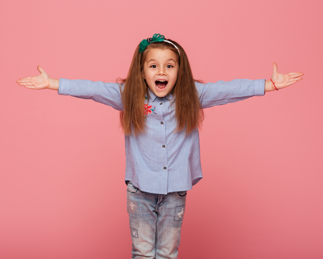 Счастливая маленькая девочка на розовом фоне