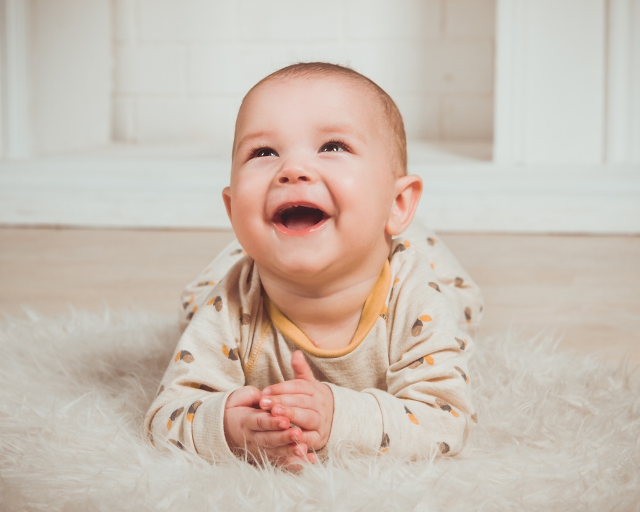 Смеющийся малыш лежит на полу
