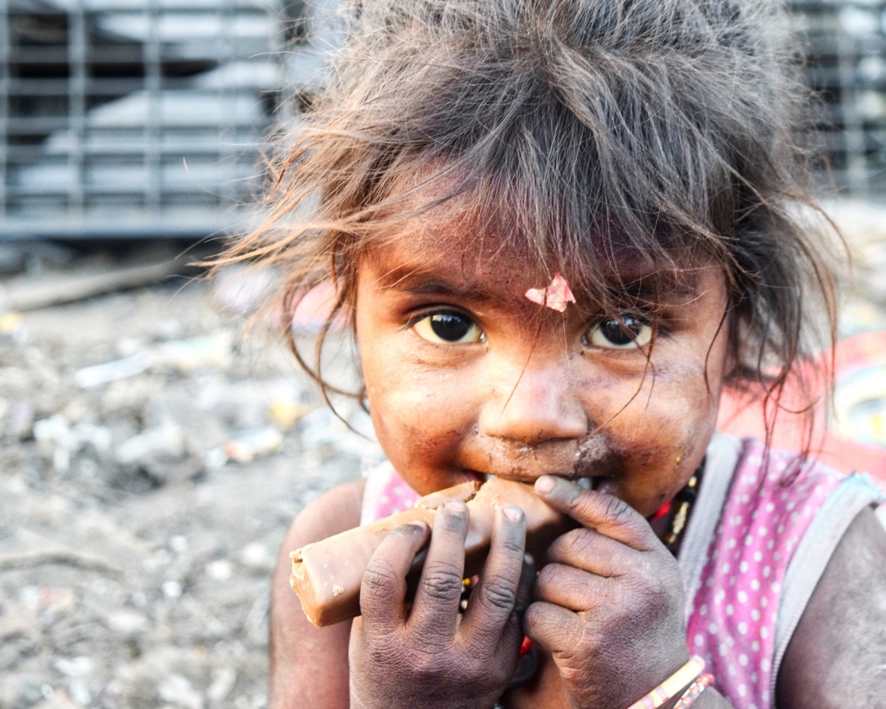 Маленькая азиатская девочка с конфетой в руках