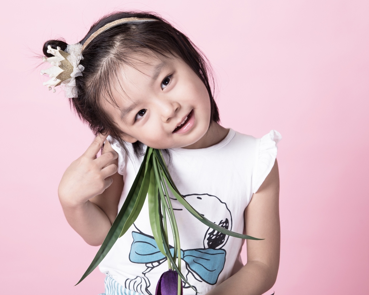 Маленькая девочка азиатка на розовом фоне