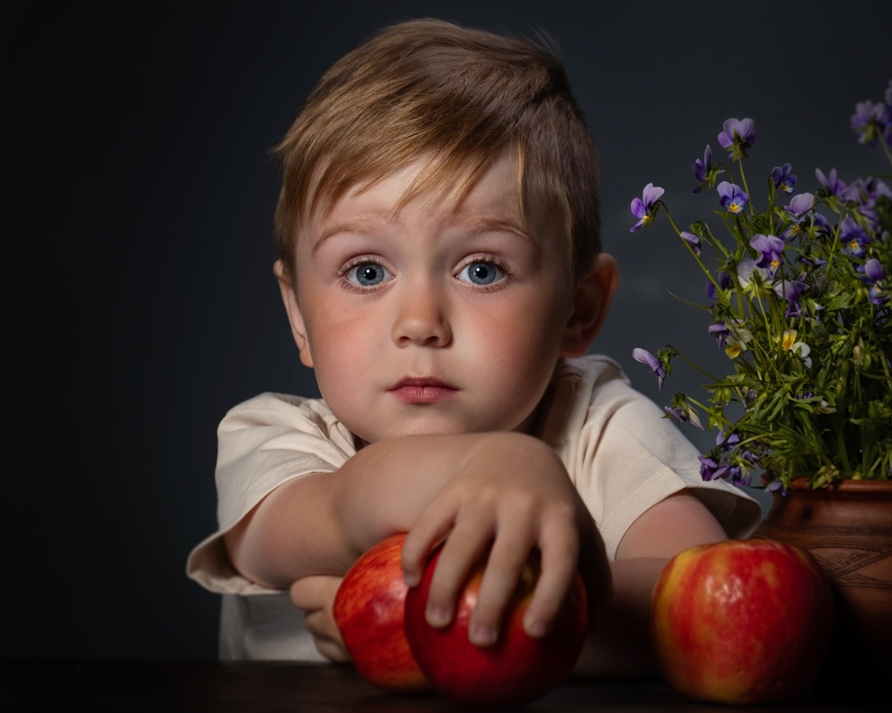 Маленький голубоглазый мальчик с яблоками
