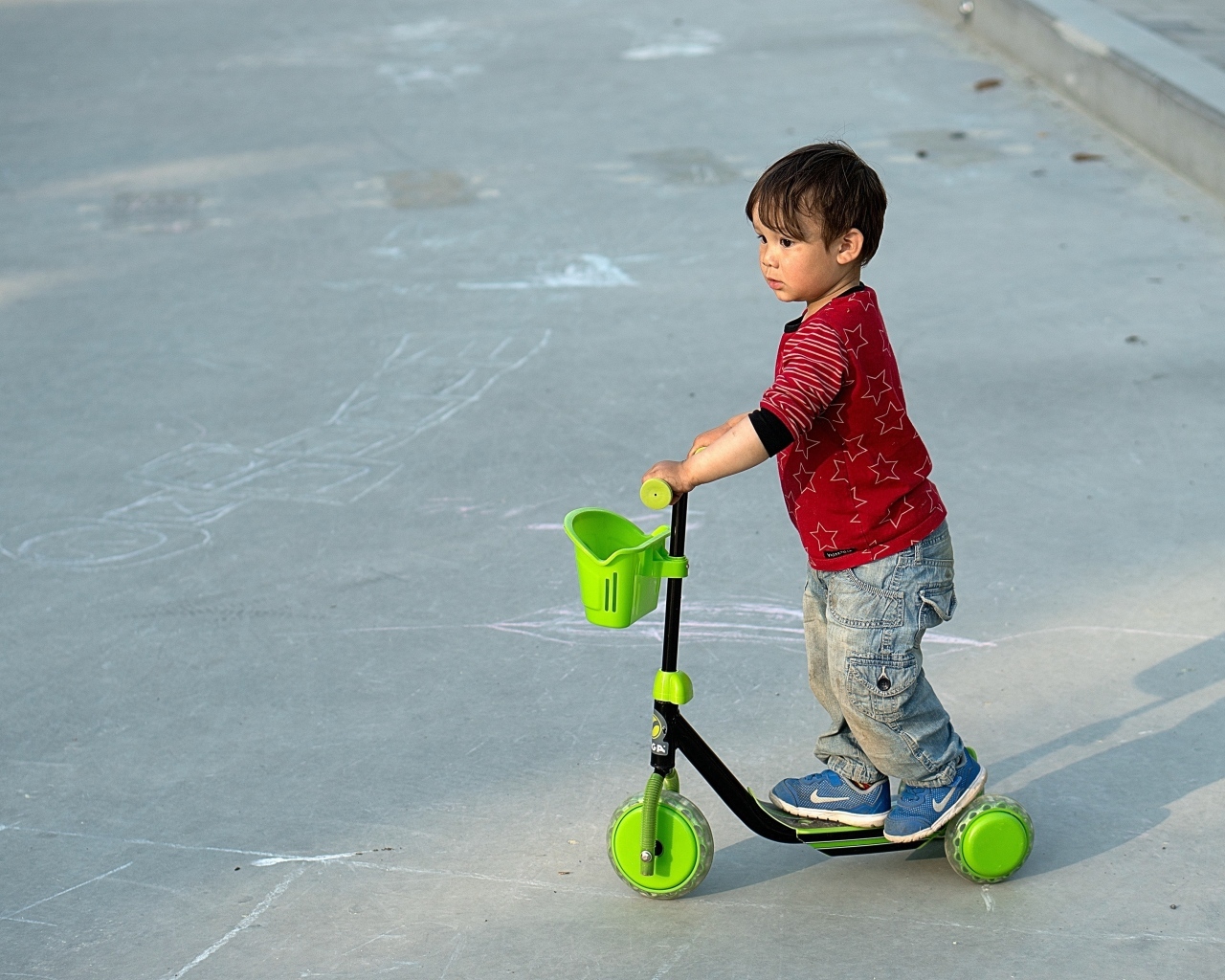 Маленький мальчик с зеленым самокатом