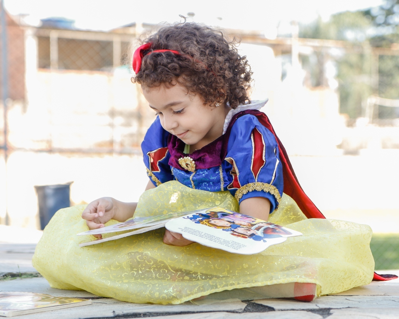 Маленькая девочка в костюме Белоснежки с книгой