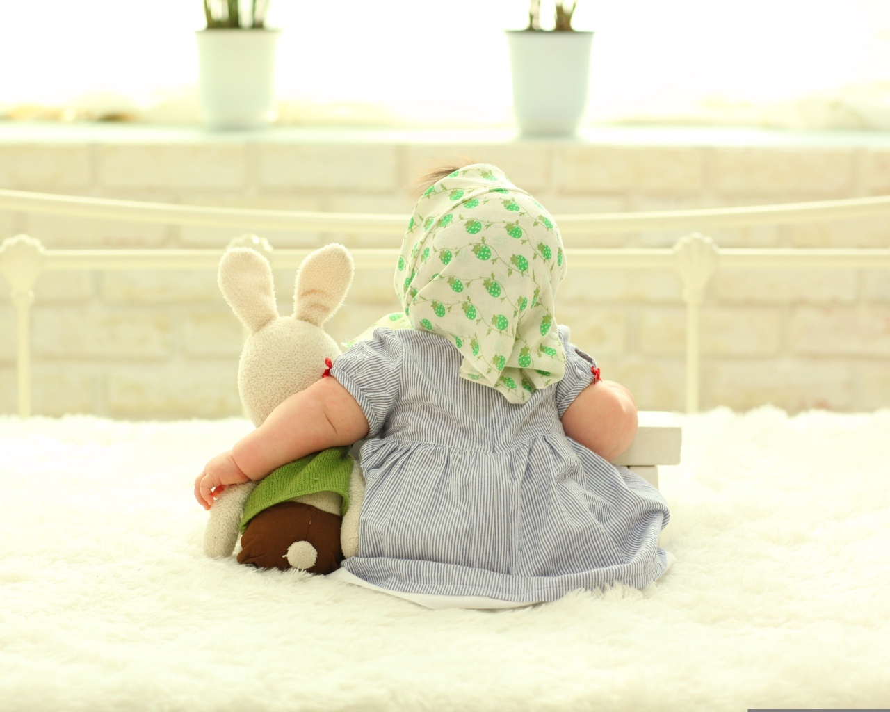 Маленькая девочка обнимает игрушечного зайца