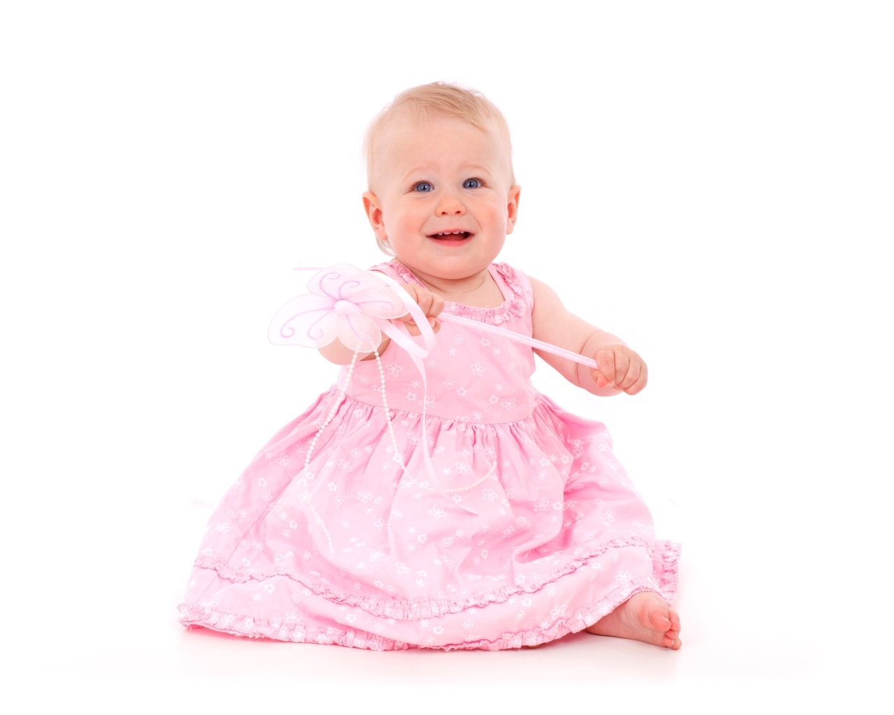 Маленькая девочка в розовом платье на белом фоне