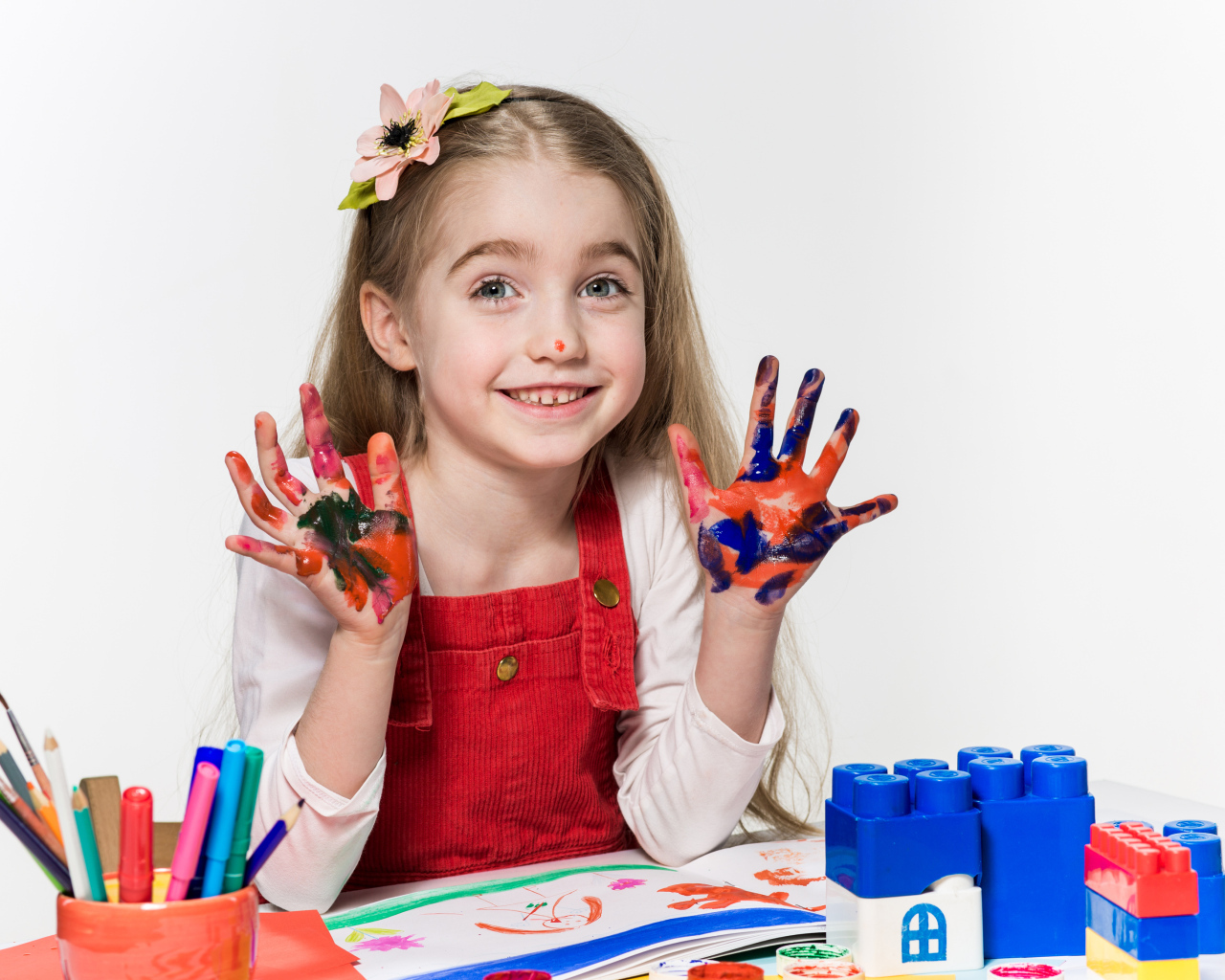 Маленькая девочка рисует красками