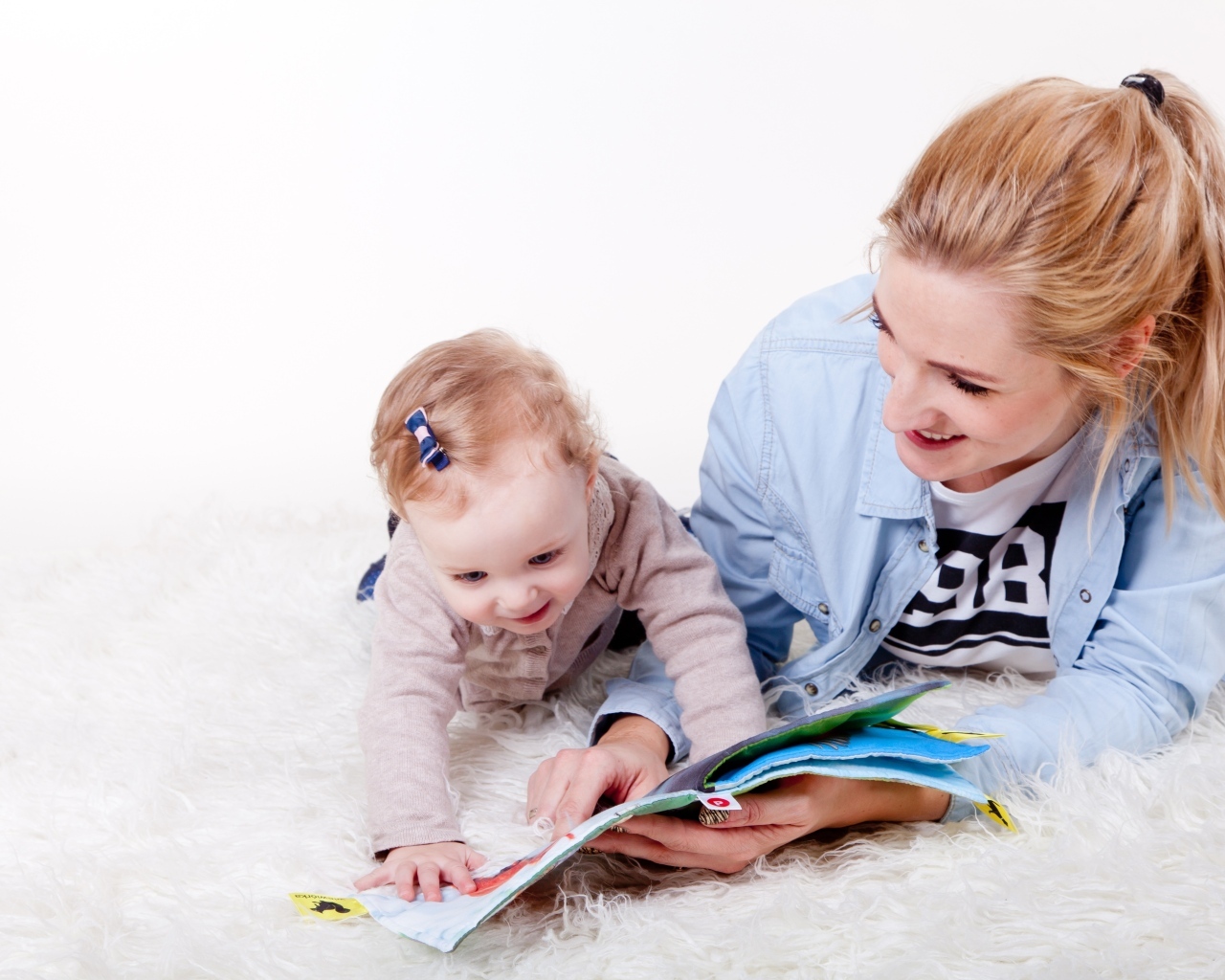 Мама читает книгу с девочкой 