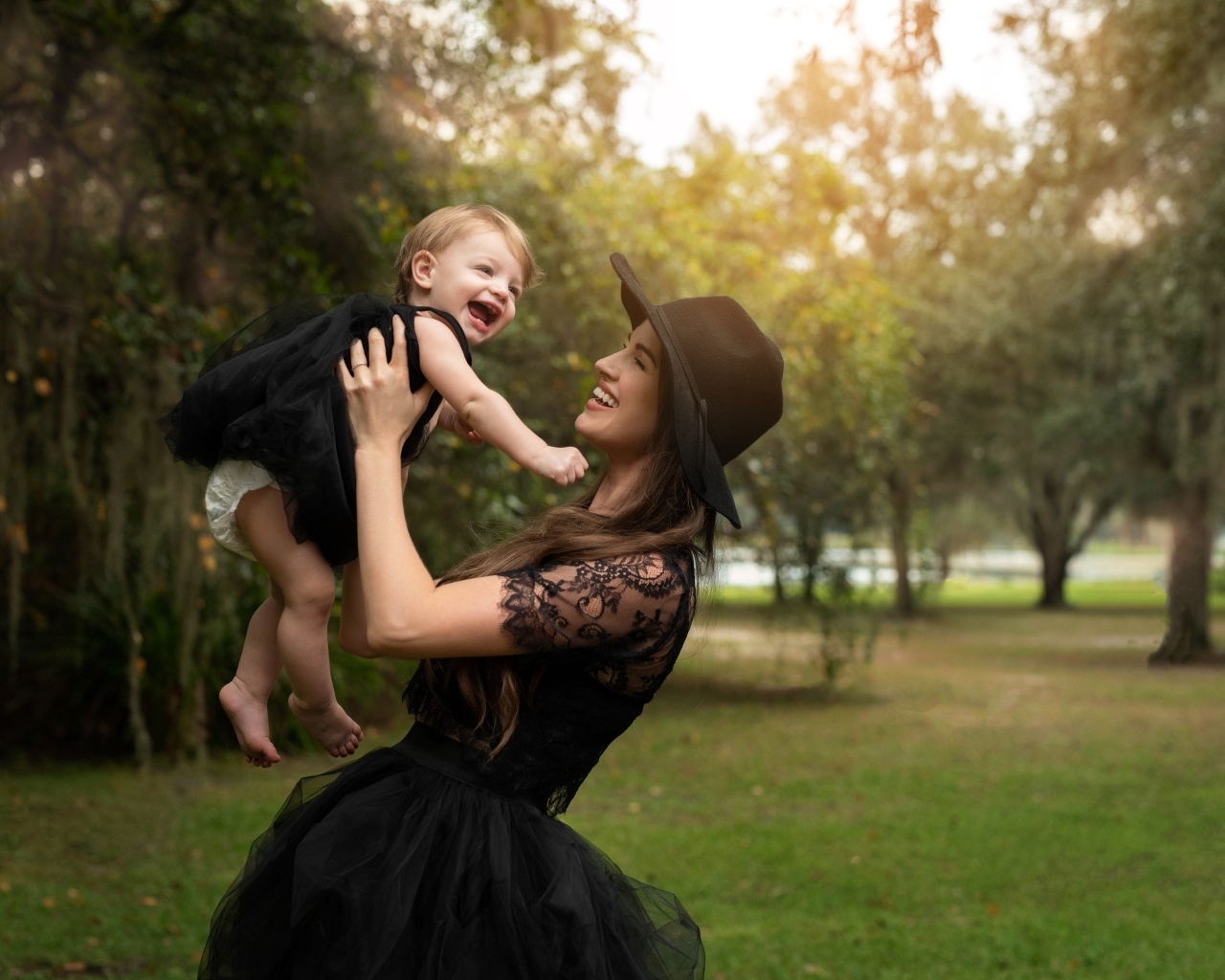 Мама держит улыбающуюся дочь на руках