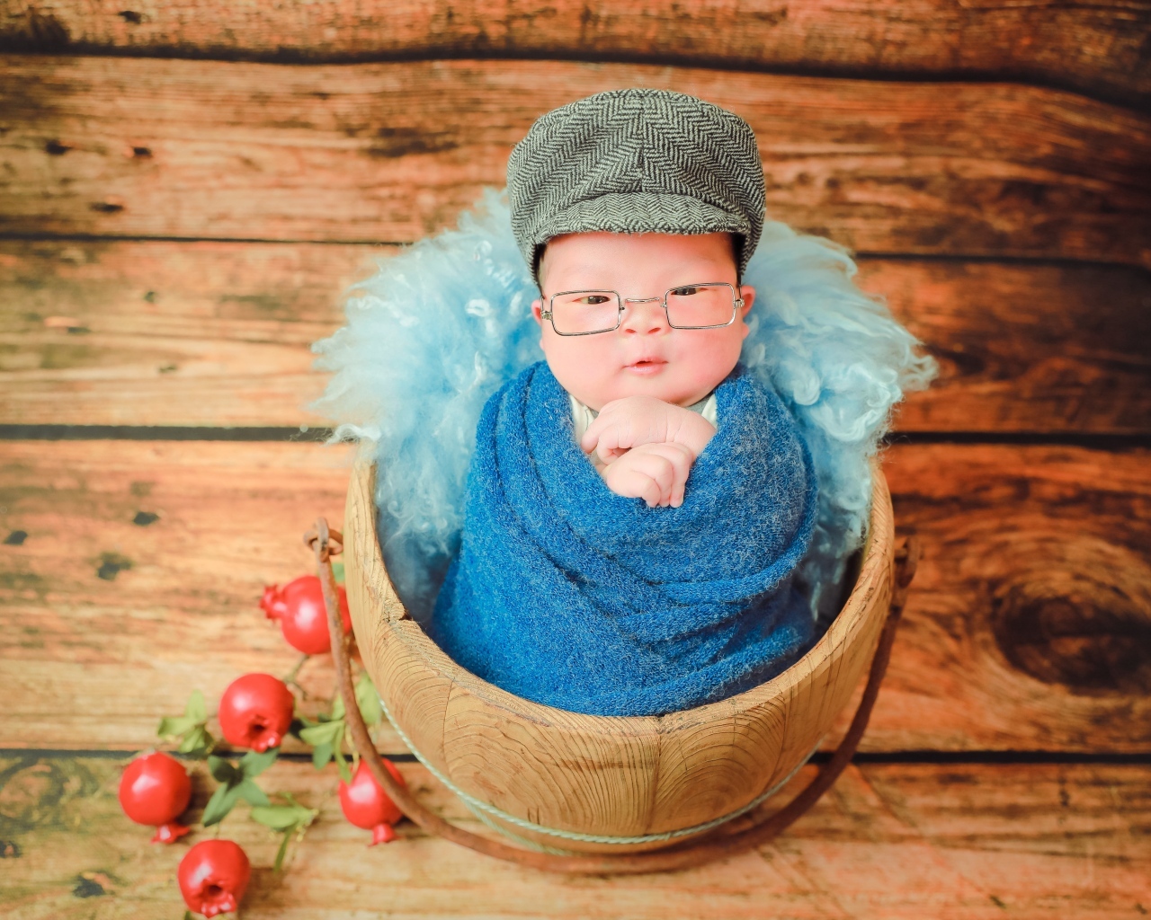 Новорожденный малыш в покрывале с кепкой на голове