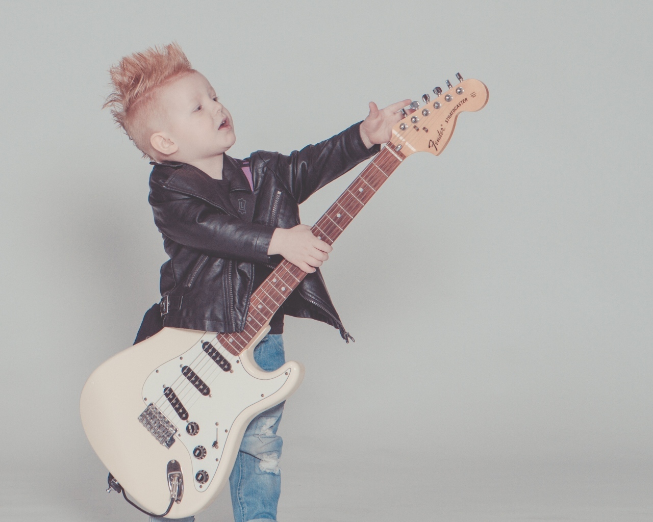 Мальчик рокер с гитарой на сером фоне