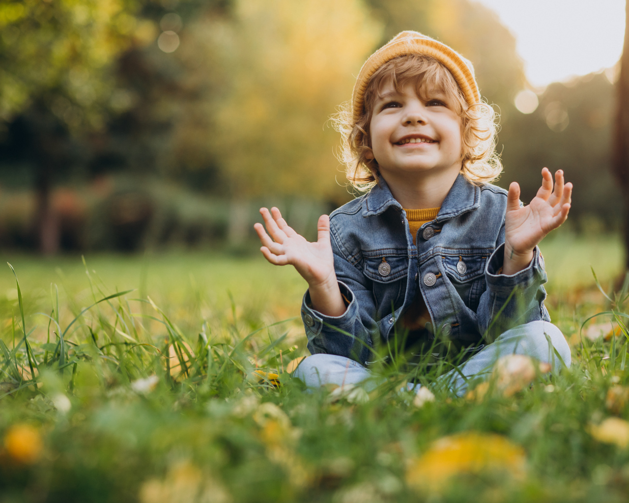 Улыбающийся ребенок сидит на траве