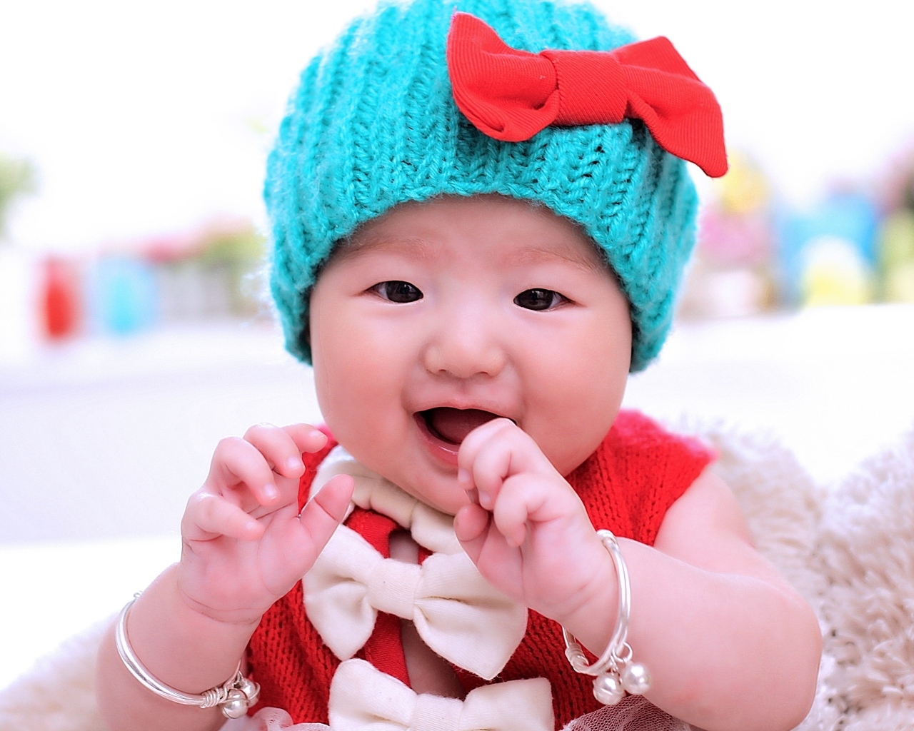 Улыбающаяся девочка в зеленой вязаной шапке