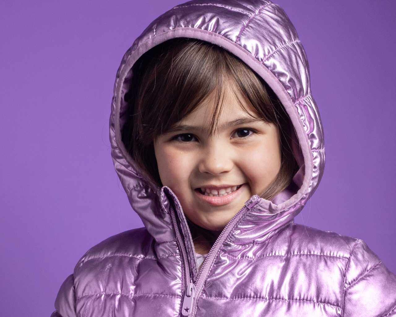 Улыбающаяся девочка в сиреневой куртке
