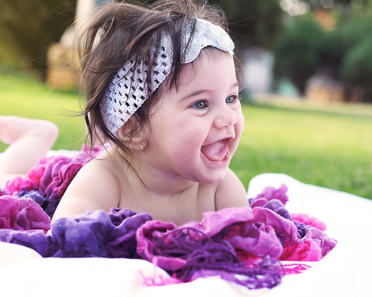 Улыбающаяся маленькая девочка с повязкой на голове 