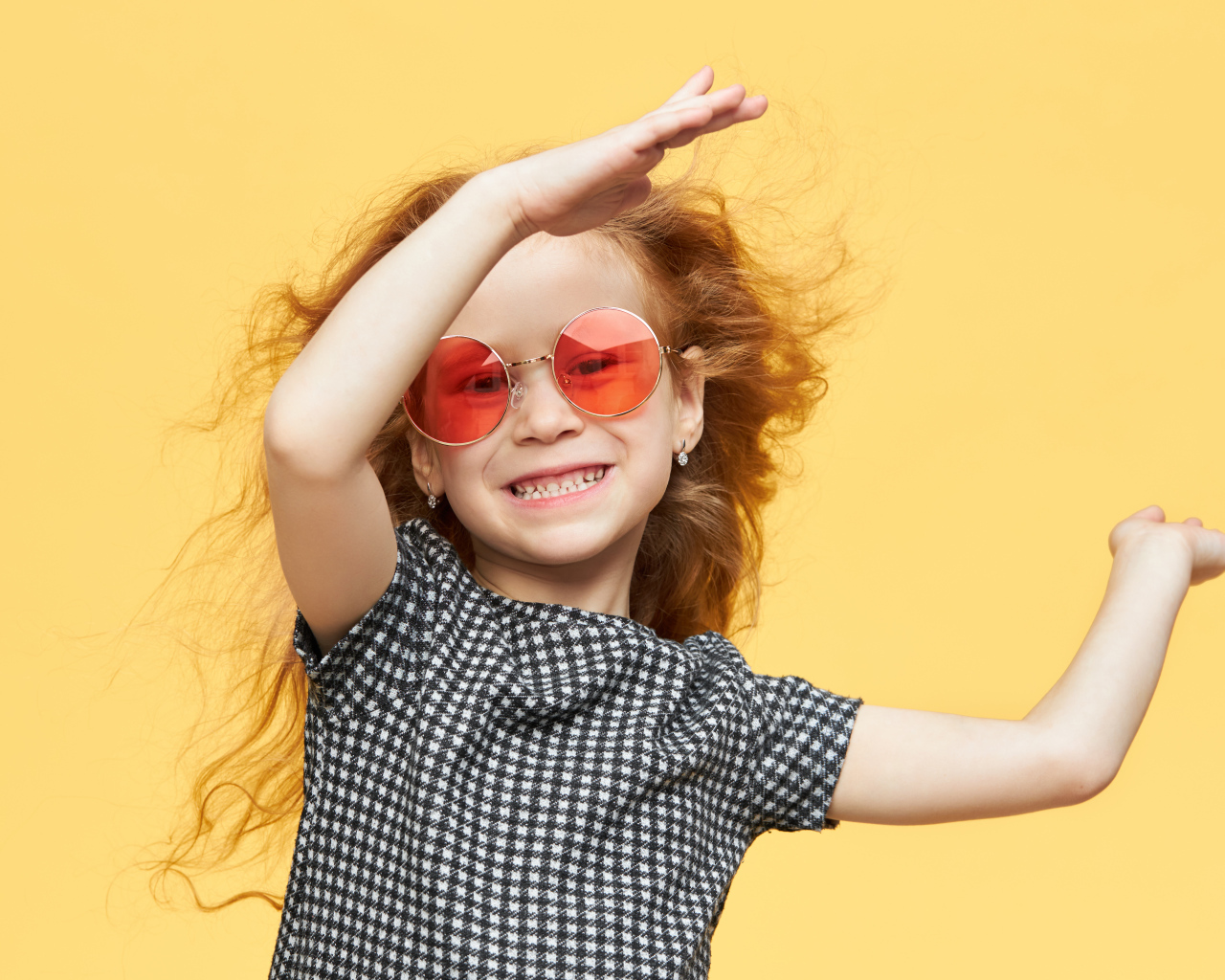 Улыбающаяся рыжеволосая девочка в очках