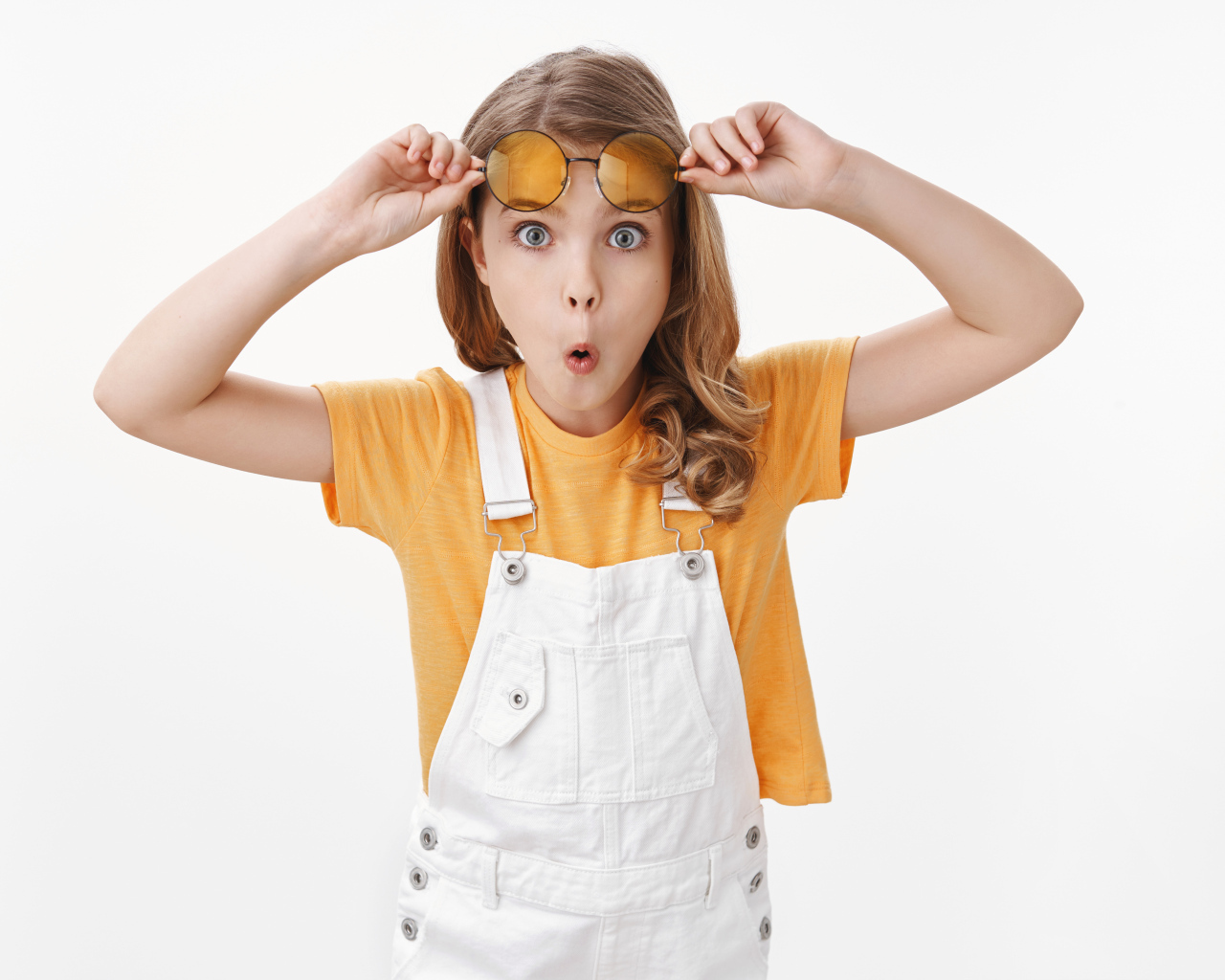 Удивленная девочка в очках на белом фоне