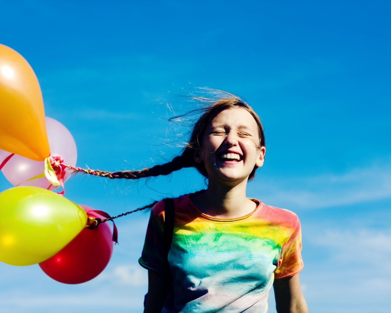 У веселой девочки шарики привязаны к косам